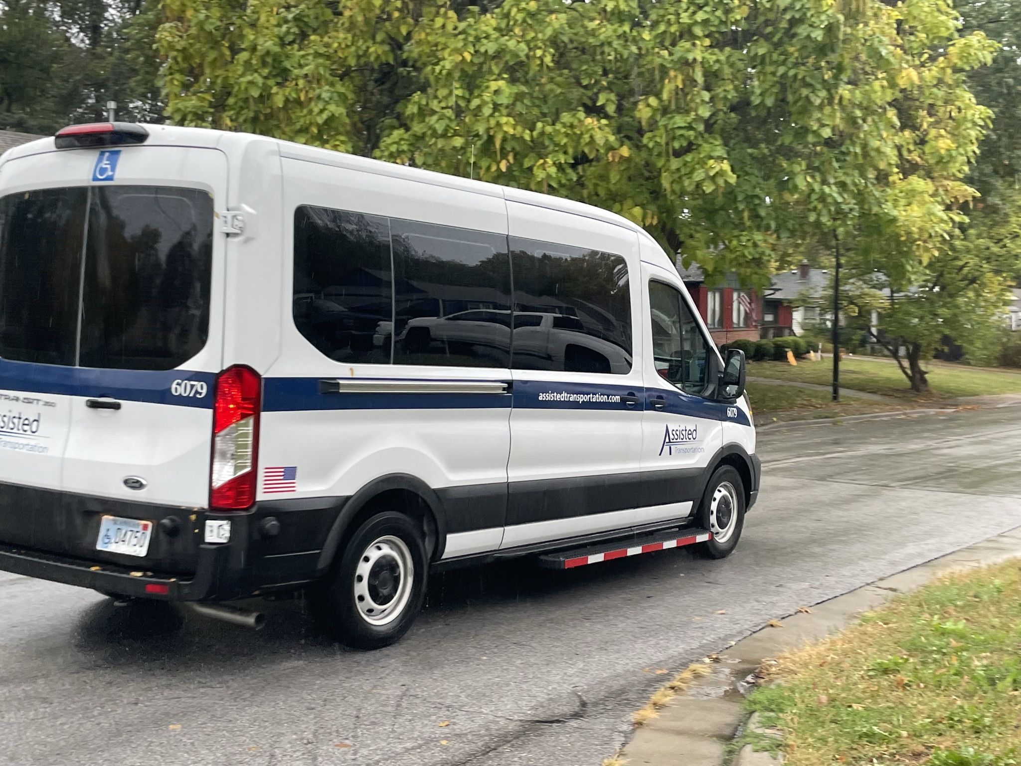 An Assisted Van drives down a residential street