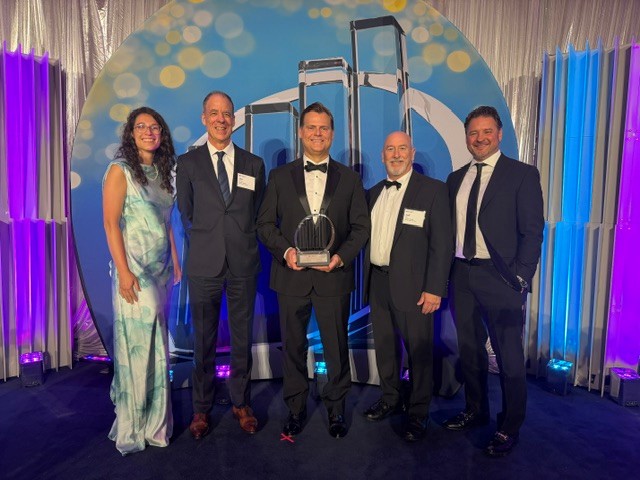 Tod Eskra accepts the Entrepreneur of the Year award surrounded by his colleagues.
