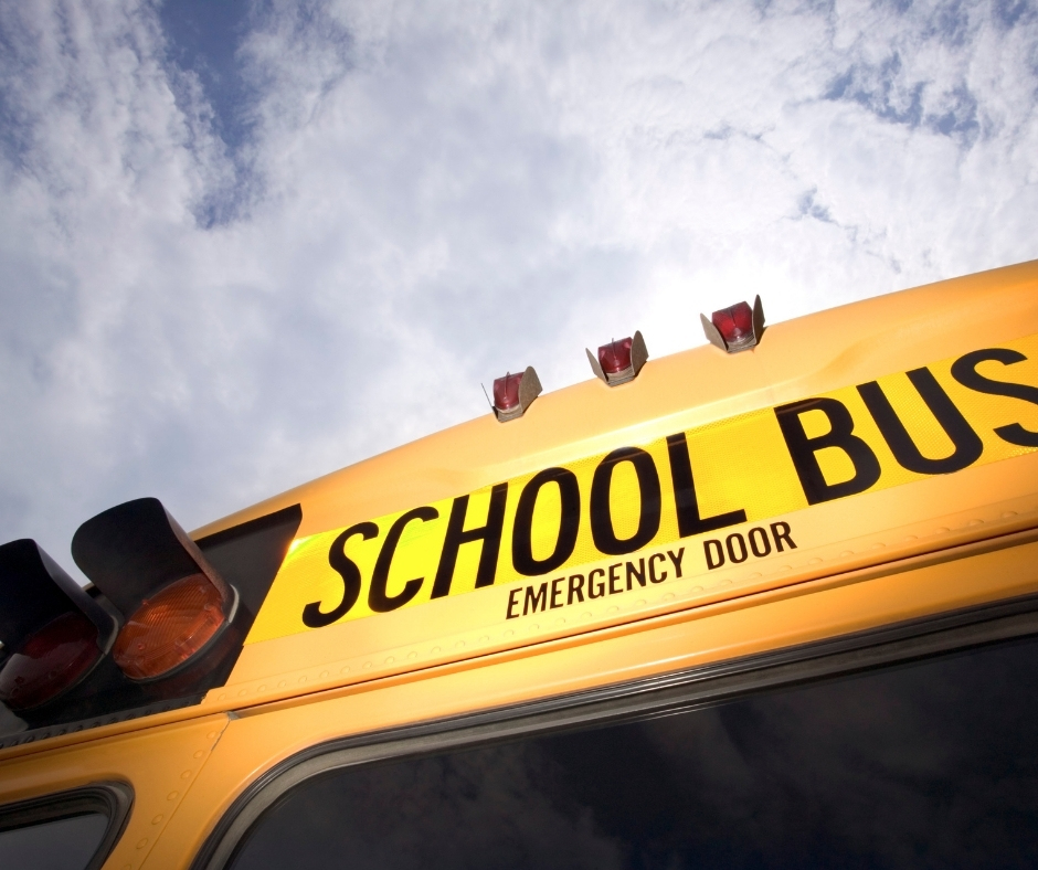 The back of a yellow school bus with the emergency door sign